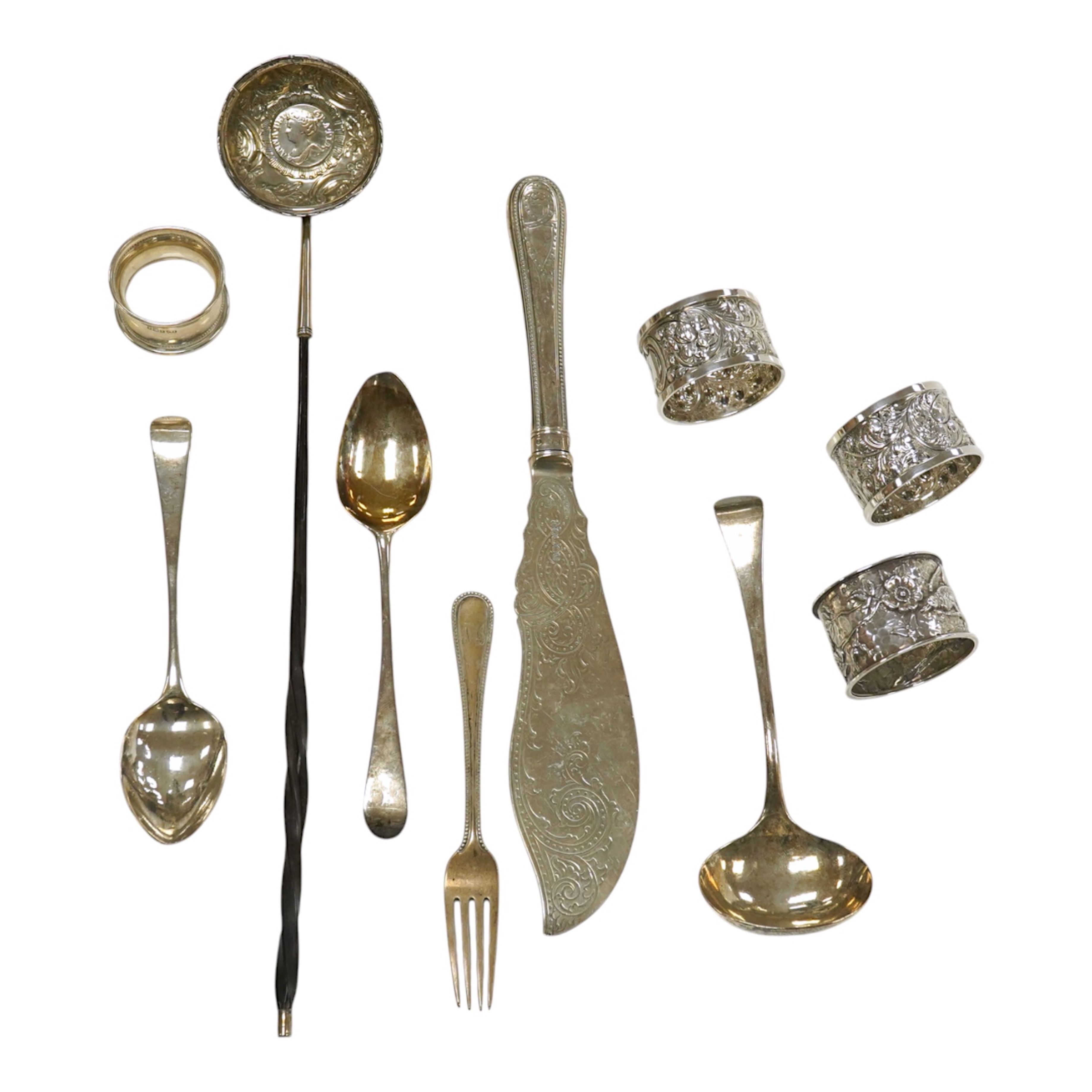 Small silver including a pair of napkin rings and two others, a Georgian sauce ladle and two similar dessert spoons, a fish slice, fork and an unmarked toddy ladle with inset coin bowl. Condition - poor to fair